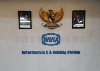 huruf timbul akrilik logo perusahaan WIKA di dinding kantor modern