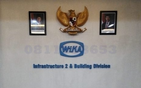 huruf timbul akrilik logo perusahaan WIKA di dinding kantor modern